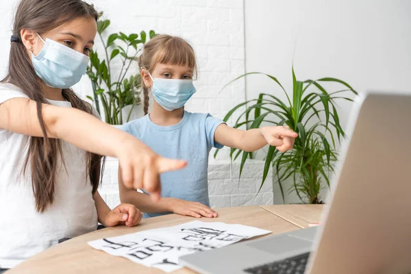 Κοριτσάκι χαιρετάει τη δασκάλα της ενώ έχει βιντεοκλήση πάνω από το laptop μαζί της και homeschooling κατά τη διάρκεια της επιδημίας coronavirus — Φωτογραφία Αρχείου