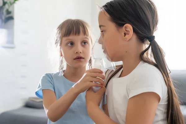 Negen jaar oud kind met allergische astma, inademen van haar medicatie door middel van spacer terwijl ze kijkt naar met haar vermoeide ogen — Stockfoto