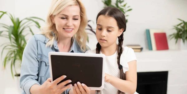 Torniamo a scuola. Bambino felice e adulto sono seduti alla scrivania. Ragazza che fa i compiti o l'educazione online. — Foto Stock