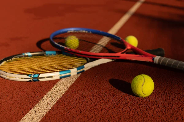 Vue rapprochée de deux raquettes et balles de tennis sur le court de tennis. — Photo