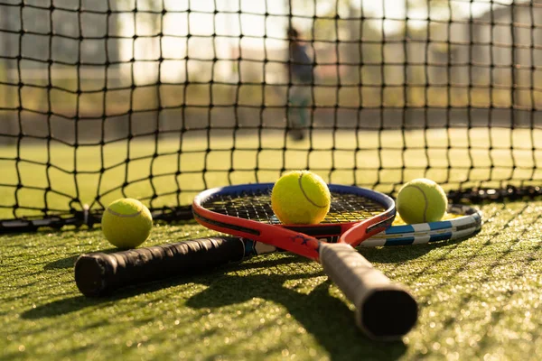 Close-up zicht op twee tennisrackets en ballen op de tennisbaan. — Stockfoto