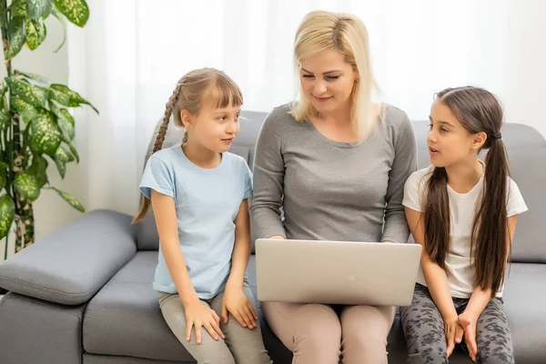 Sorridente madre con i bambini che utilizzano il computer portatile a casa — Foto Stock