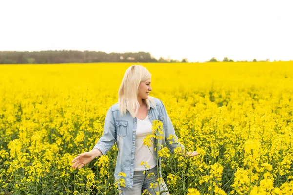 夕日の光と菜の花畑に魅力的な女性の肖像画。黄色の花と幸せな女性 — ストック写真