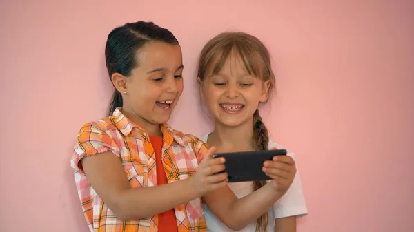 Happy little girls with a smartphone in hands communicate at home with loved ones using modern technology — Stock Photo, Image