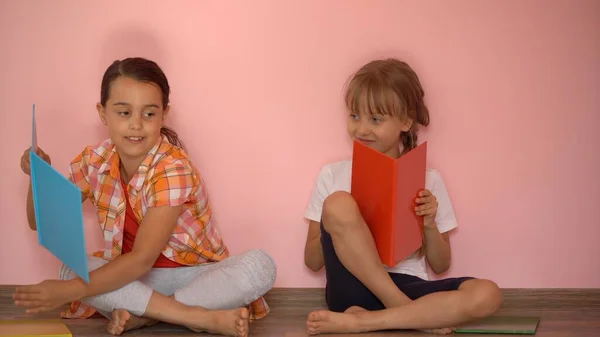 Kleine Mädchen lesen im Wohnzimmer ein Buch. Kluge Schulmädchen erledigen nach der Schule ihre Hausaufgaben. Bildung und Fernunterricht für Kinder. Hausaufgabenbetreuung während der Quarantäne. Bleiben Sie zu Hause. — Stockfoto