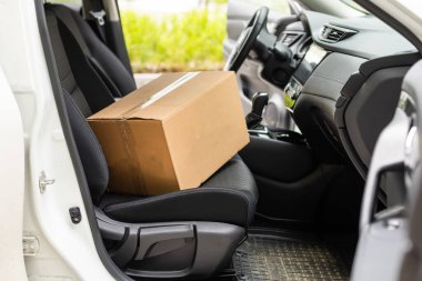 Kargo şoförü koltukta paketler ile araba kullanıyor.