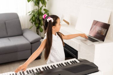Küçük kız çevrimiçi ders öğretim görevlisi olarak bir sentezleyiciyi nasıl öğreneceğini izliyor.