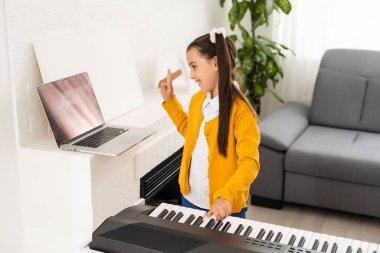 Küçük kız çevrimiçi ders öğretim görevlisi olarak bir sentezleyiciyi nasıl öğreneceğini izliyor.