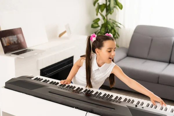 어린 소녀가 신시사이저를 연주하는 법을 배웁니다. 악기 연주를 배우는 것. — 스톡 사진