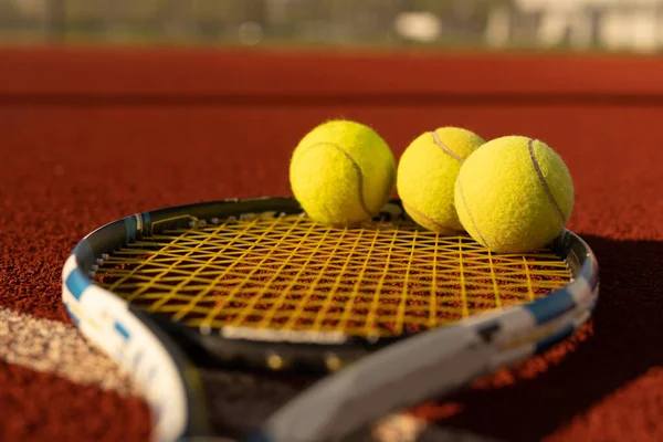 Tennisracket en nieuwe tennisbal op een pas geverfde tennisbaan — Stockfoto