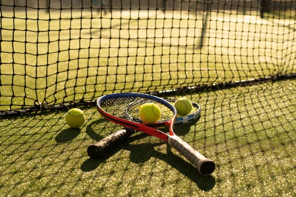 Tenisová raketa a nový tenisový míček na čerstvě natřeném tenisovém kurtu — Stock fotografie