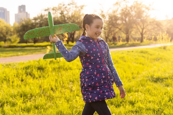 Criança brincando com avião. Menina feliz jogar ao ar livre — Fotografia de Stock