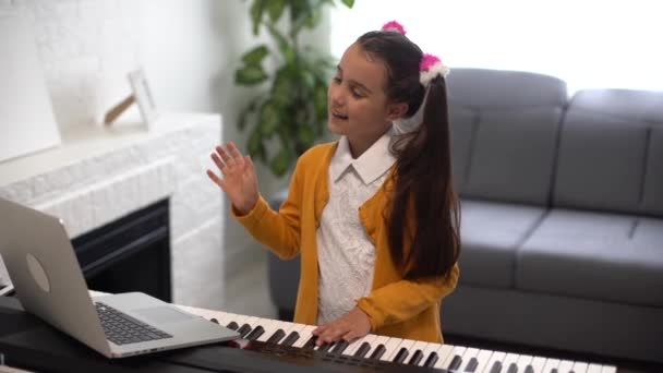 Petite fille regarder leçon en ligne tutoriel comment apprendre un synthétiseur — Video