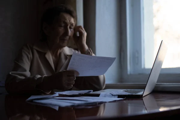 Mujer jubilada calculando sus facturas domésticas —  Fotos de Stock