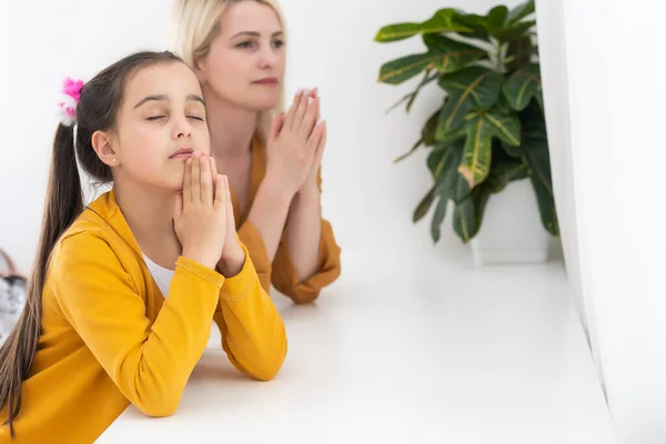 Mother and daughter reading from the bible and praying — Stock Photo, Image