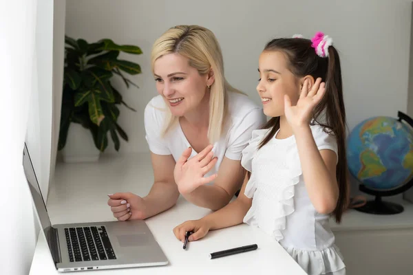 Educação online de crianças. Mãe e filha da pré-escola assistindo a uma chamada de vídeo lição bate-papo em casa. — Fotografia de Stock