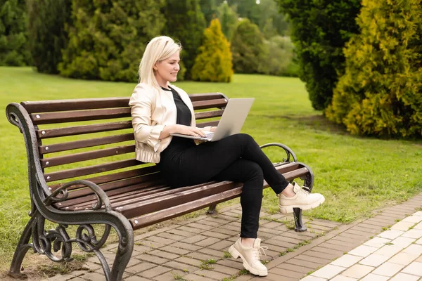 Πορτρέτο της πολυάσχολης γυναίκας πωλήσεων που κάθεται στο επιχειρηματικό πάρκο και χρησιμοποιεί το laptop της. Επιχειρηματίας εργάζεται σε απευθείας σύνδεση — Φωτογραφία Αρχείου