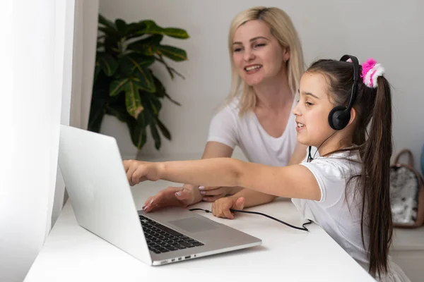 Educazione online dei bambini. Madre e figlia della scuola materna guardando una video lezione chiamata chat a casa. — Foto Stock