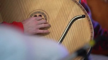 Bandura çalan bir adam, parmaklar ve müzik aleti