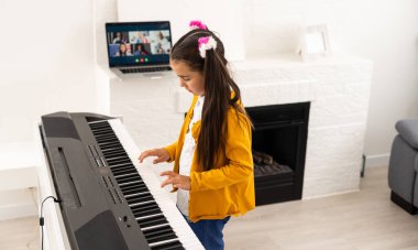 Küçük kız çevrimiçi ders öğretim görevlisi olarak bir sentezleyiciyi nasıl öğreneceğini izliyor.