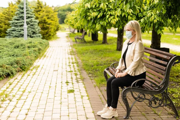 Frau trägt Gesichtsmaske im Park — Stockfoto