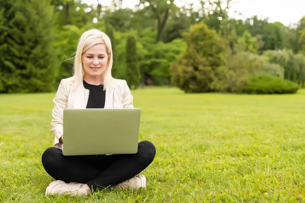 Mujer con portátil relajante en el parque — Foto de Stock