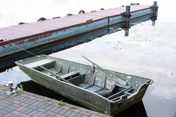 Ensam roddbåt vid sjön i vattnet. Fiskebåt av trä — Stockfoto