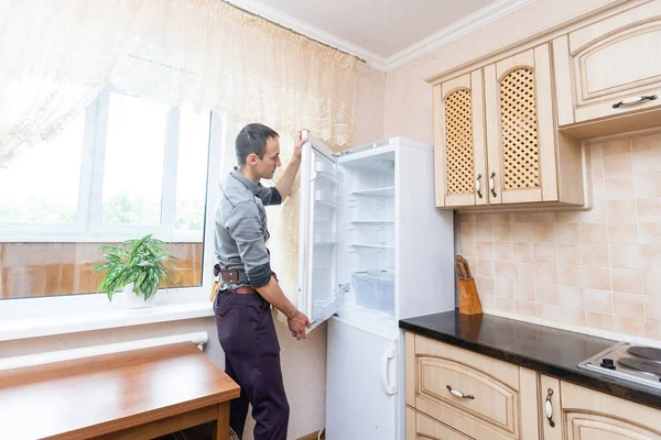 Jovem Homem Reparador Fixação Frigorífico Na Cozinha — Fotografia de Stock