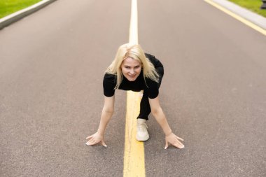 Açık havada spor yapan bir kadın. Egzersiz yapan genç bayan koşmaya hazır. Sağlık ve spor konsepti.