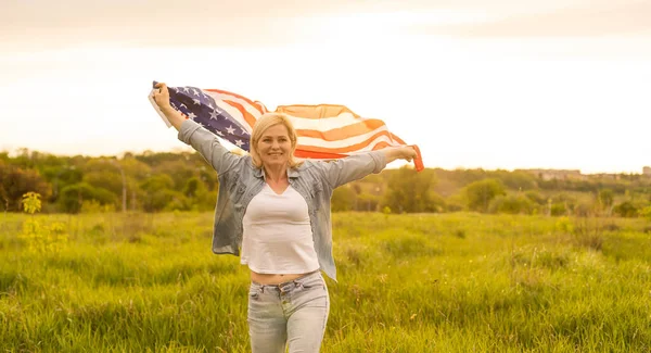 Land, patriotism, självständighetsdag och människor koncept - glad leende ung kvinna med nationell amerikansk flagga på fältet — Stockfoto