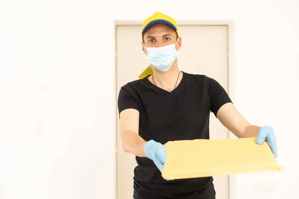 Homem de entrega em luvas protetoras e uma máscara — Fotografia de Stock