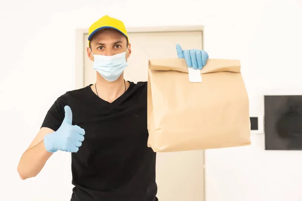 Homem de entrega em luvas protetoras e uma máscara — Fotografia de Stock