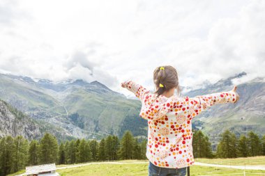 Alp dağlarında yürüyüş yapan çocuklar. Çocuklar Avusturya 'daki dağa bakarlar. Bahar tatili. Açık hava eğlencesi ve sağlıklı aktivite.