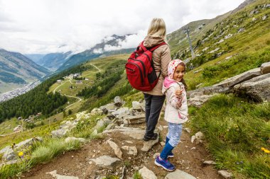 Anne ve çocuklara dağların eteklerinde yürüyüşe çıkmalarına.