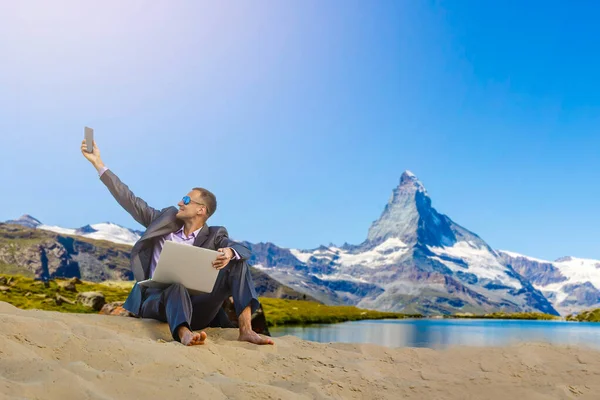 Homme avec ordinateur portable sur le sommet de la montagne — Photo