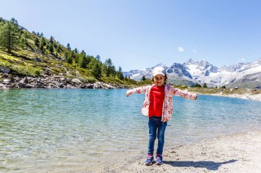 Küçük bir kız gezgin dağların arka planında