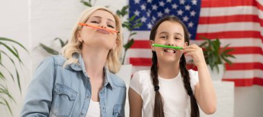Memleketinde Amerikan bayrağı taşıyan mutlu anne ve kız.