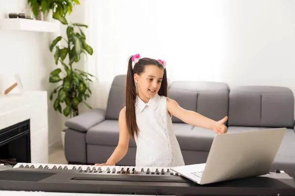 Petite fille regarder leçon en ligne tutoriel comment apprendre un synthétiseur — Photo