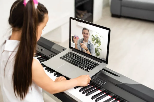 Criança a tocar piano. Lição de música online com professor por