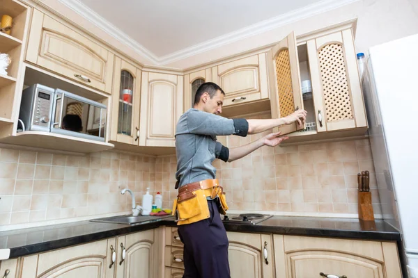 Instalação da cozinha. Trabalhador montagem de móveis — Fotografia de Stock