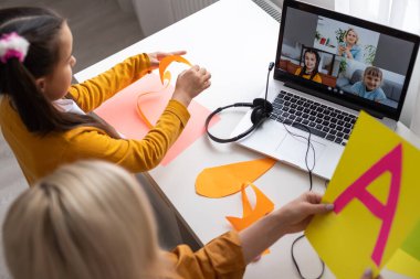 Annesiyle kağıt origami yapan mutlu bir kız.