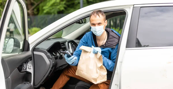 Kargo şoförü koltukta paketler ile araba kullanıyor.