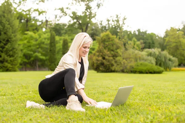 Mulher com laptop relaxante no parque — Fotografia de Stock