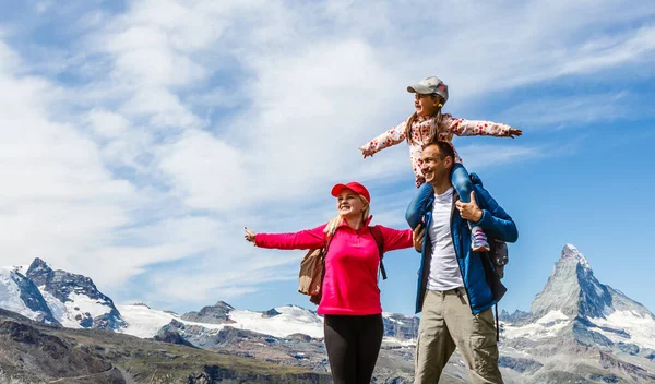 Küçük çocuklu mutlu bir aile yaz mevsiminde İsviçre dağlarında yürüyüş yapıyor. Manzarada eğlenen gençler. Seyahat kavramı, dost canlısı aile. — Stok fotoğraf