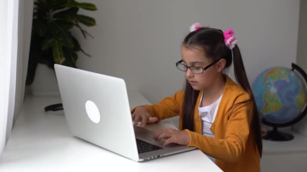 Una persona usando un ordenador portátil hija pequeña que trabaja en el ordenador portátil. — Vídeos de Stock