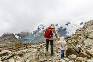 Anne ve çocuklara dağların eteklerinde yürüyüşe çıkmalarına.