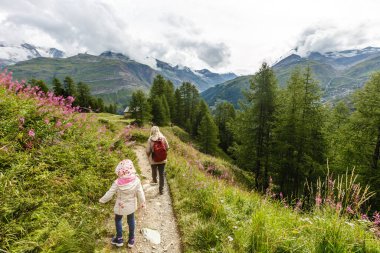 Anne ve çocuklara dağların eteklerinde yürüyüşe çıkmalarına.
