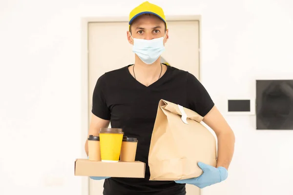 Homem de entrega em luvas protetoras e uma máscara — Fotografia de Stock
