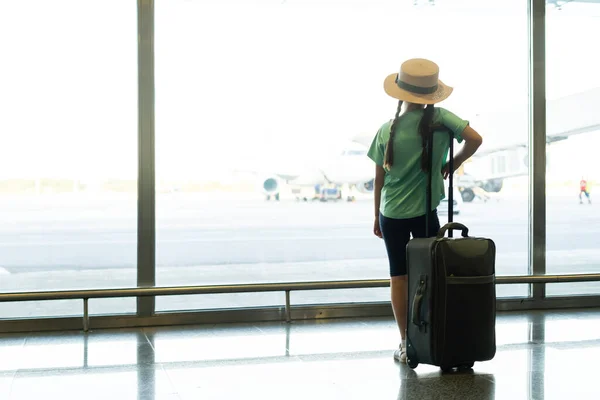 Kleines Mädchen mit Koffer reist am Flughafen, Kinder reisen — Stockfoto