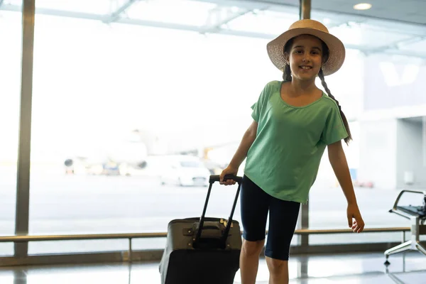 Piękna dziewczynka posiadająca paszport i kartę pokładową na lotnisku — Zdjęcie stockowe